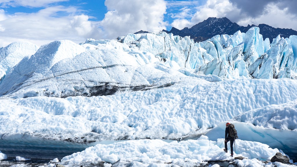 A man hiking on a glacier in Alaska.