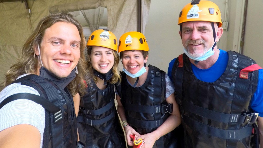 Four people wearinng helmets and vests, getting ready to do a zipline in Puerto Rico.