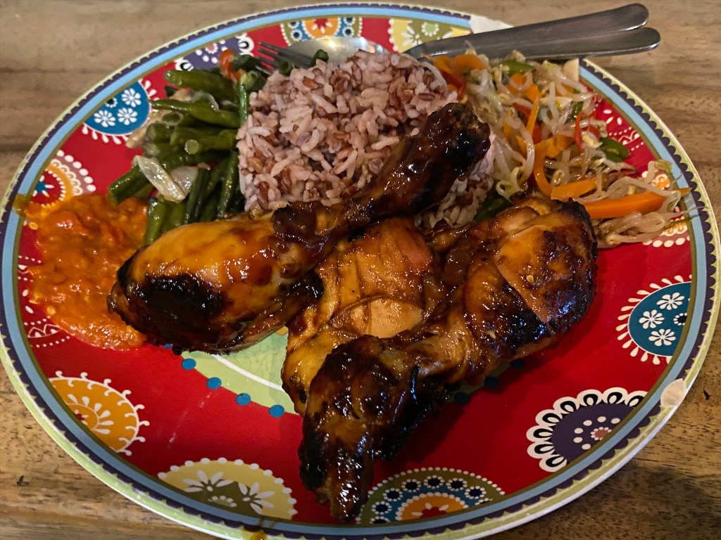 A platter of Indonesian food, including chicken, rice, and vegetables at Varuna Warung in Canggu, Bali.