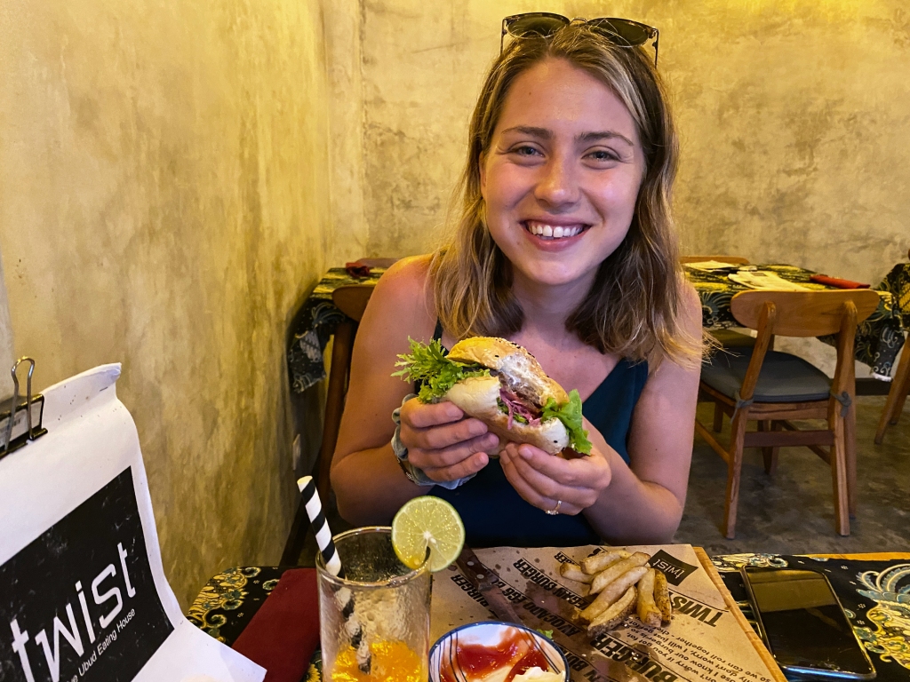 A woman eating a burger in a restaurant.