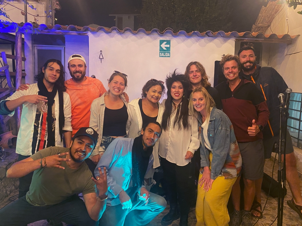 A group of adults posing with a band at a bar in Cusco, Peru.