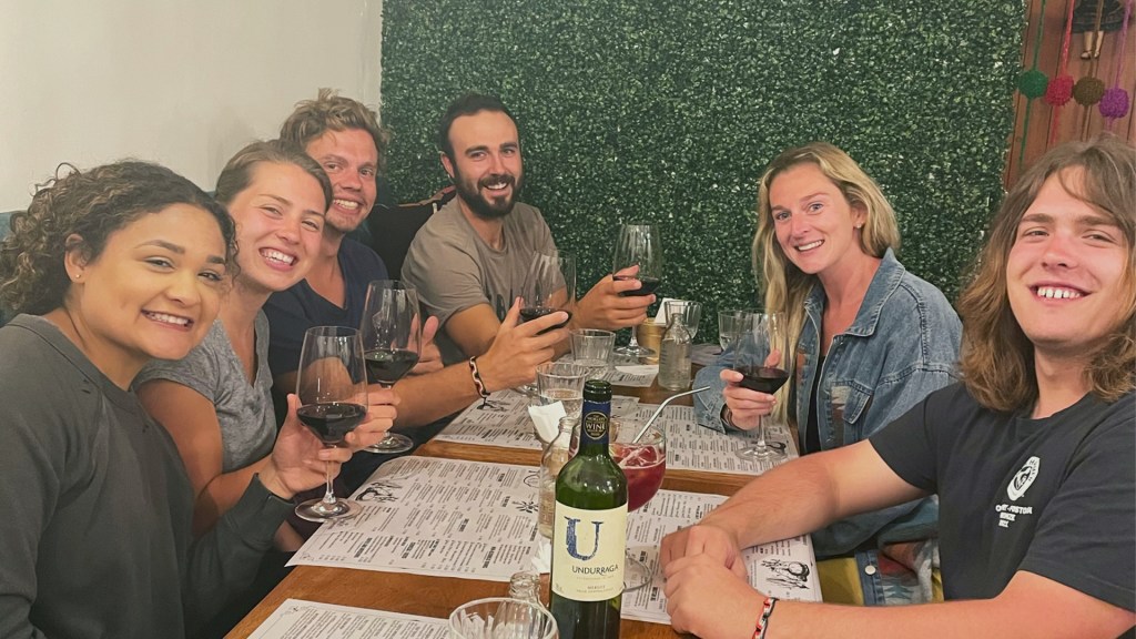 A group of 6 adults drinking wine at a restaurant in Cusco, Peru.