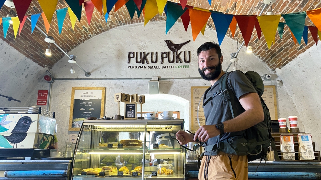 A man standing at the counter of a cafe named Puku Puku in Arequipa, Peru.