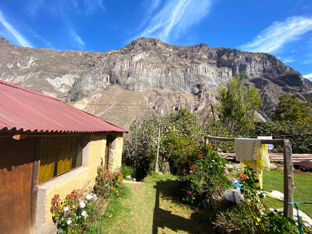 A yellow house with a red roof inside of Colca Canyon in Peru.