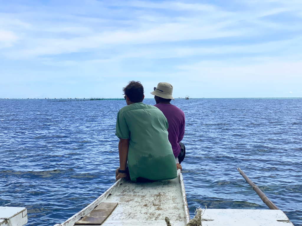 Two men sitting on the front end of a boat in Panglao, Philippines.