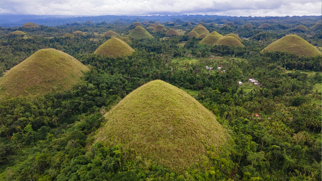 The Chocolate Hills in Bohol, Philippines. A group of pointy shaped, grassy hills.