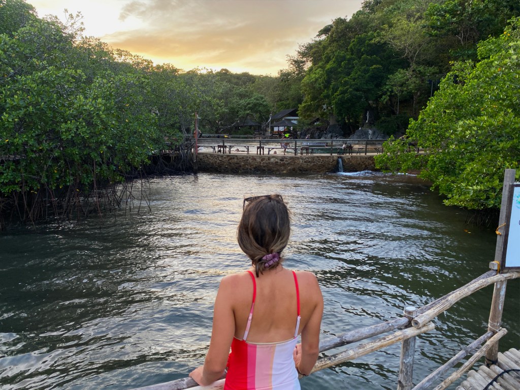 A woman watching the sunset at the Maquinit Hot Springs in Coron, Philippines.