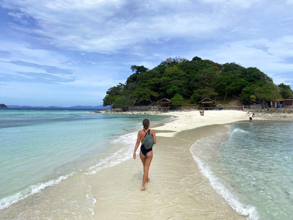 A woman walking on a sandbar in Coron, Philippines.