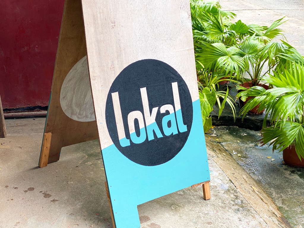 A wooden restaurant sign reading "Lokal" in Siargao.